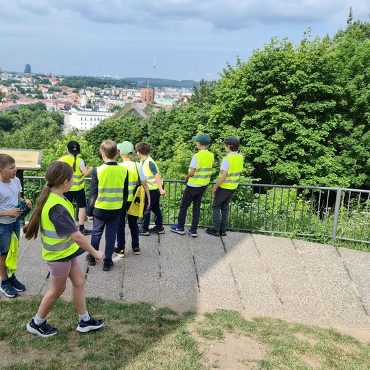 Mokinukai bėgioja po Trijų Kryžių kalno apžvalgos aikštelę.