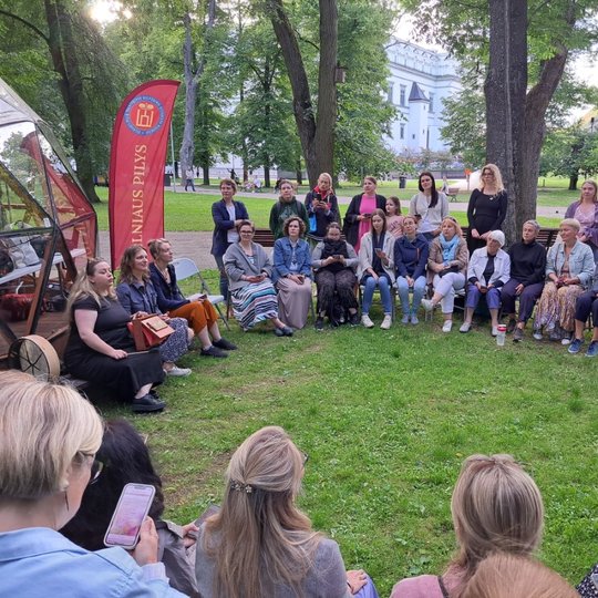 Moterys Sereikiškių parke, susėdę ratu, dainuoja sutartines.