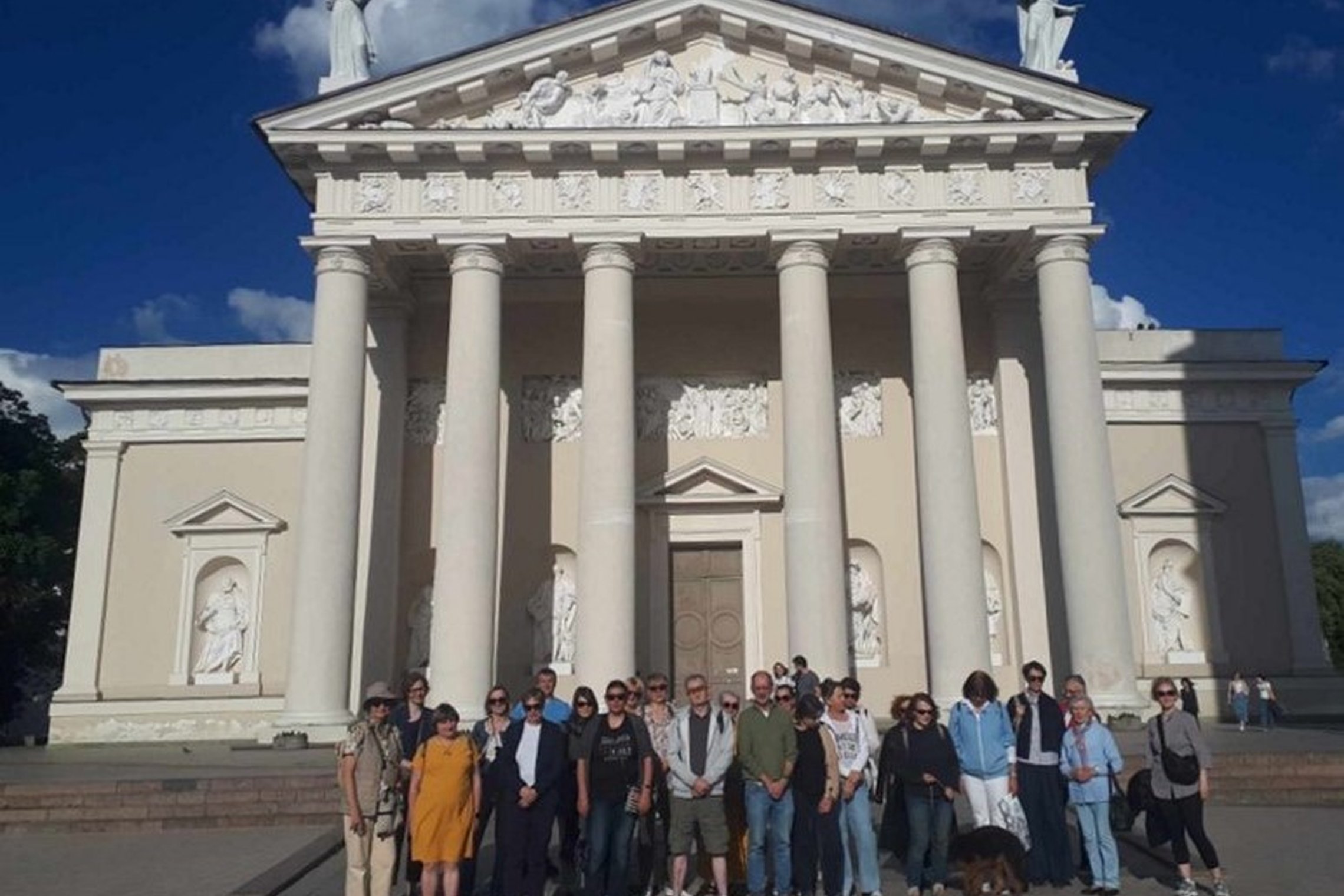 Grupė ekskursijos dalyvių Arkikatedros fasadinėje pusėje.