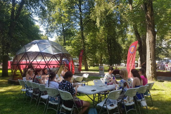 Sereikiškių parke prie Pilių kupolo ištiestas stalas. Prie jo sėdi moterys ir minko molį.
