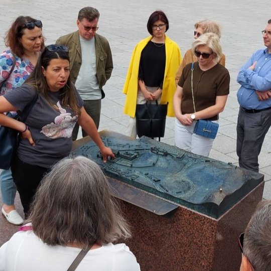 Ekskursantai ir gidė Katedros aikštėje, prie Vilniaus pilių maketo.