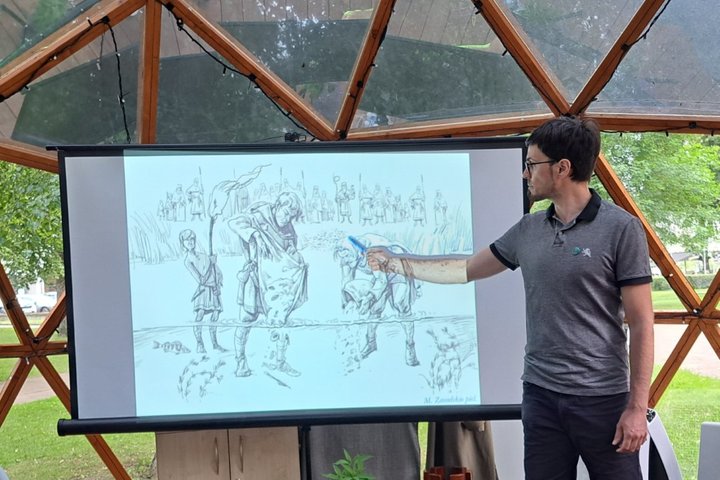 Archeologas rodo rašikliu į vaizdą projektoriuje.