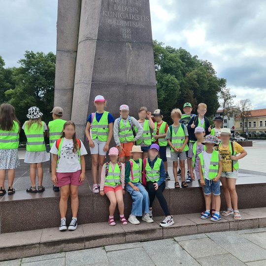 Mokinių grupė pozuoja Katedros aikštėje prie Gedimino paminklo.