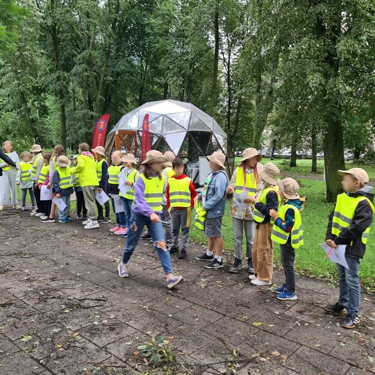 Mokinukai išsirikiavę į eilę prie Vilniaus pilių kupolo.