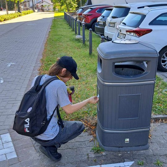 Savanoris lupa nelegaliai užlipintą lipduką nuo šiukšliadėžės prie Naujojo arsenalo.