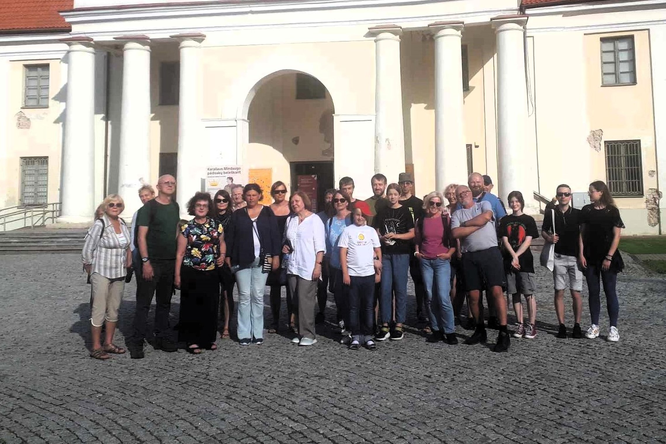 Grupė ekskursantų prie Lietuvos nacionalinio muziejaus laiptų.