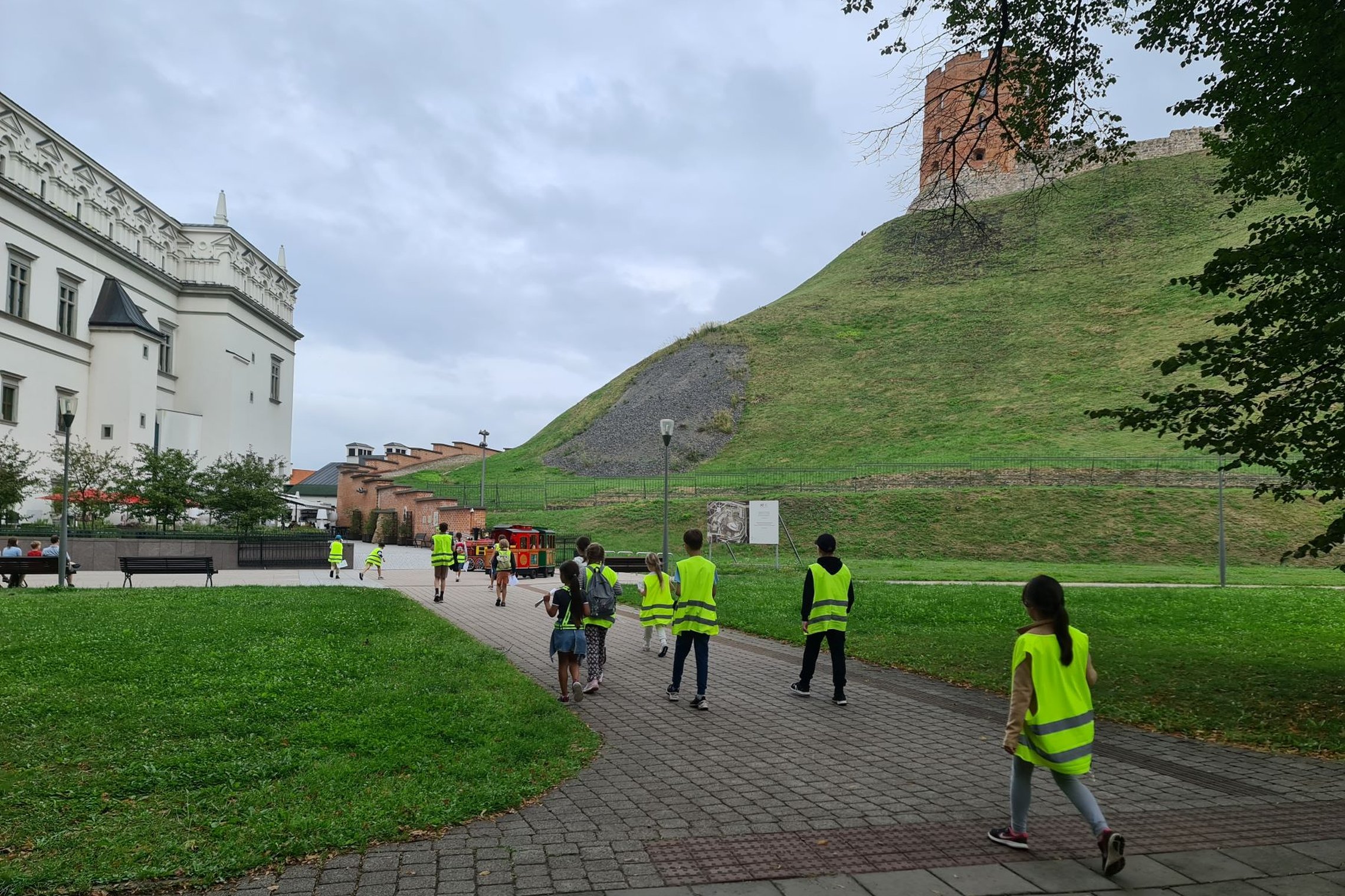 grupė vaikų bėga Sereikiškių parko taku Bonos Sforcos sodo link.