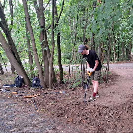 Du savanoriai purena sutryptą žemę kastuvais.