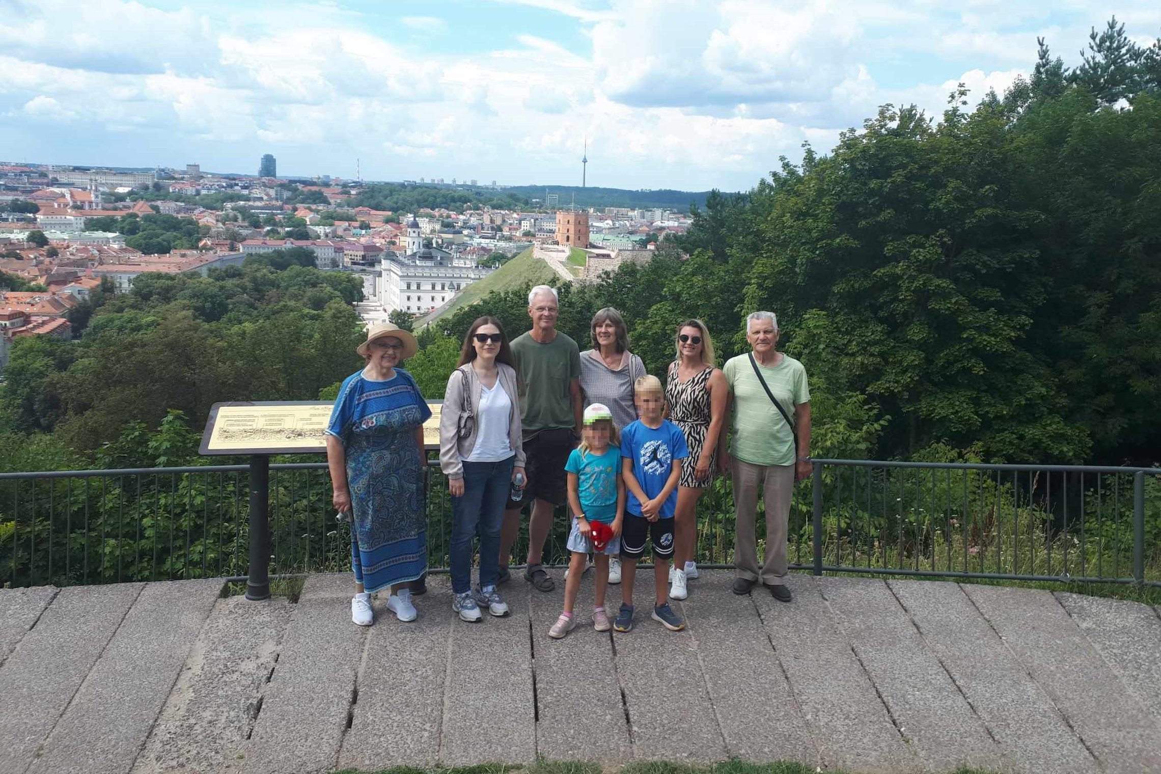 Šeima, kuri dalyvavo ekskursijoje, pozuoja ant Trijų Kryžių kalno apžvalgos aikštelės.