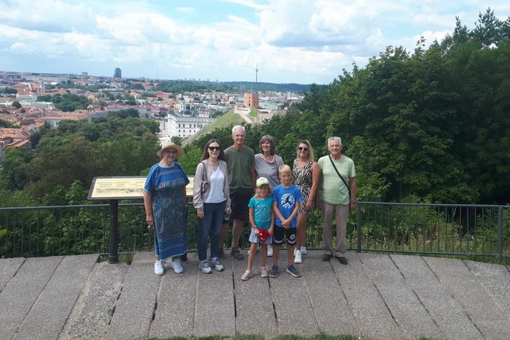 Šeima, kuri dalyvavo ekskursijoje, pozuoja ant Trijų Kryžių kalno apžvalgos aikštelės.