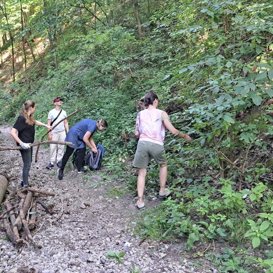 Savanoriai, kaip tikri tarzanai, su lazdomis ir poilsiauja.