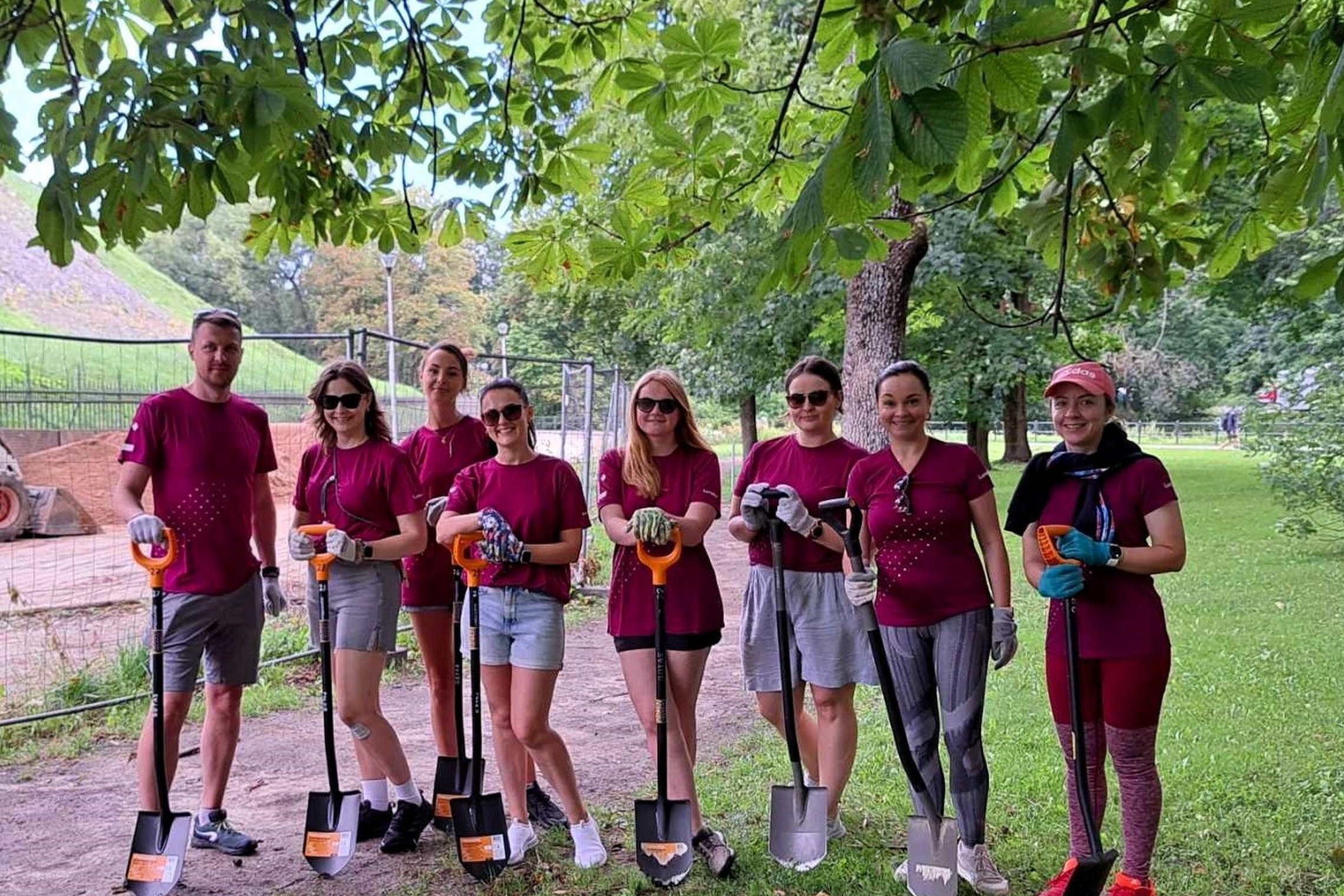 luminor savanorių komanda išsirikiavę parke, pasiruošę talkai.