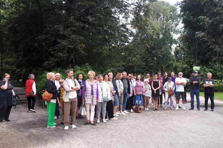 Didelė ir gausi grupė ekskursijos dalyvių stovi Bernardinų sodo take.