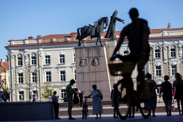 Katedros aikštės nuotrauka, kurioje matosi Gedimino paminklas ir juodi žmonių šešėliai.
