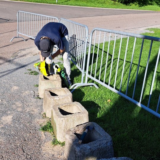 Savanoris pila žemę į lauko vazoną Kalnų parko estradoje.