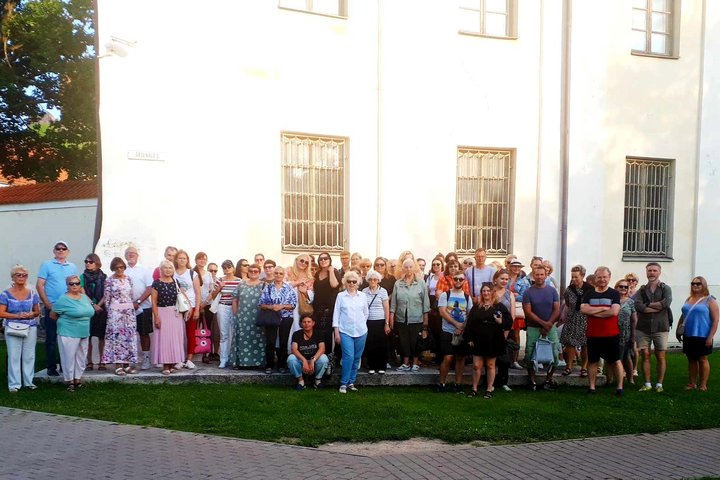Didelė grupė žmonių stovi prie Lietuvos nacionalinio muziejaus sienos.