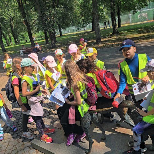 Vaikų grupė aplink Lietuviškų skalikų skulptūrą Sereikiškių parke.