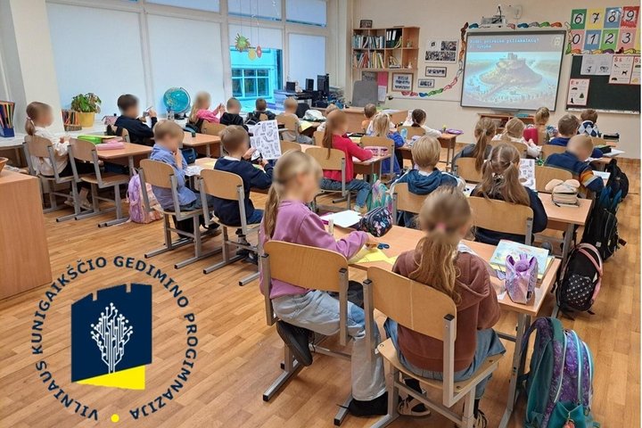 Nuotraukoje vaikai sėdi klasėje ir kuria savo piliakalnius.