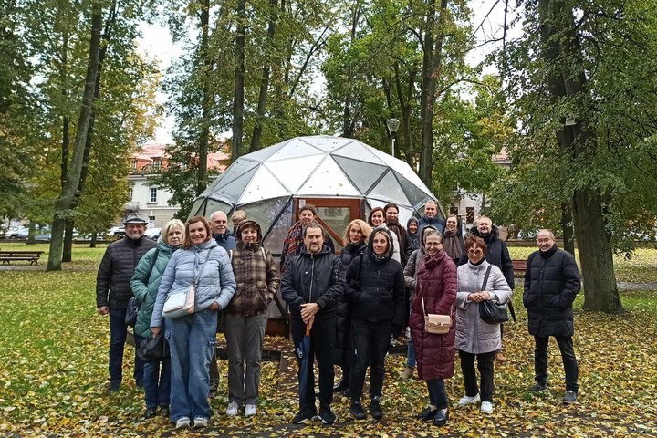 Nuotraukoje ekskursijos dalyviai, stovi ir šypsosi prie Vilniaus pilių kupolo. Anksčiau netoliese tekėjo upė Vilnia.