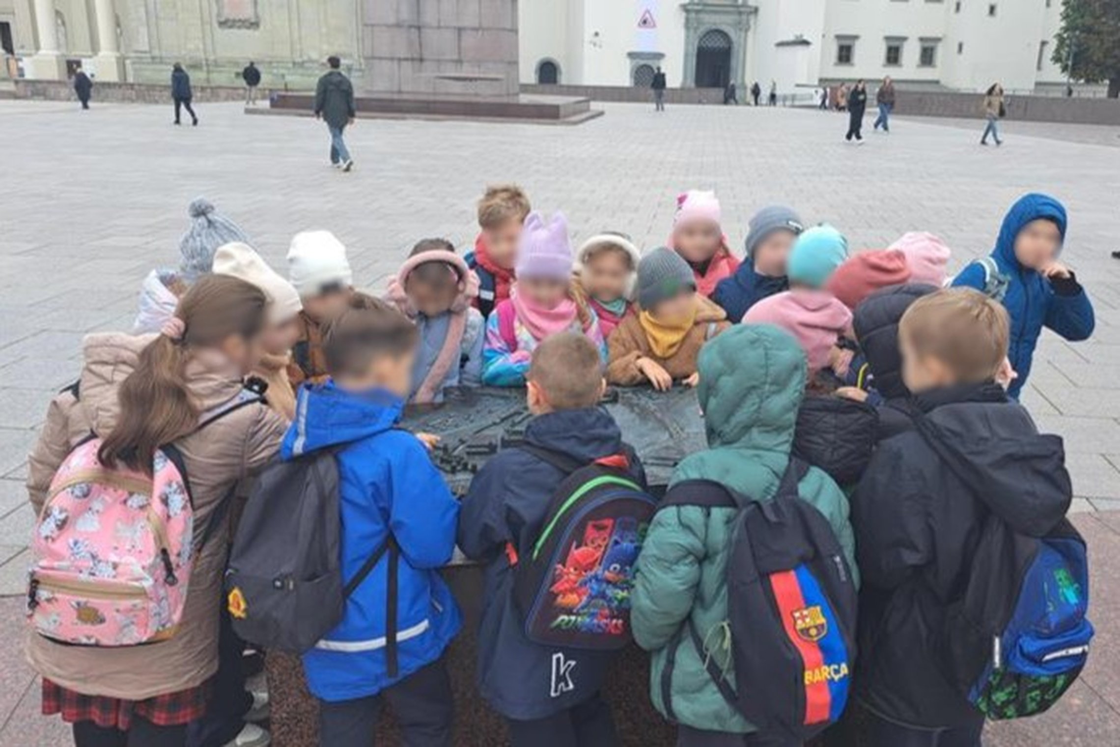 Nuotraukoje vaikai sustoję ratu, net palinkę tyrinėja Vilniaus pilių maketą.