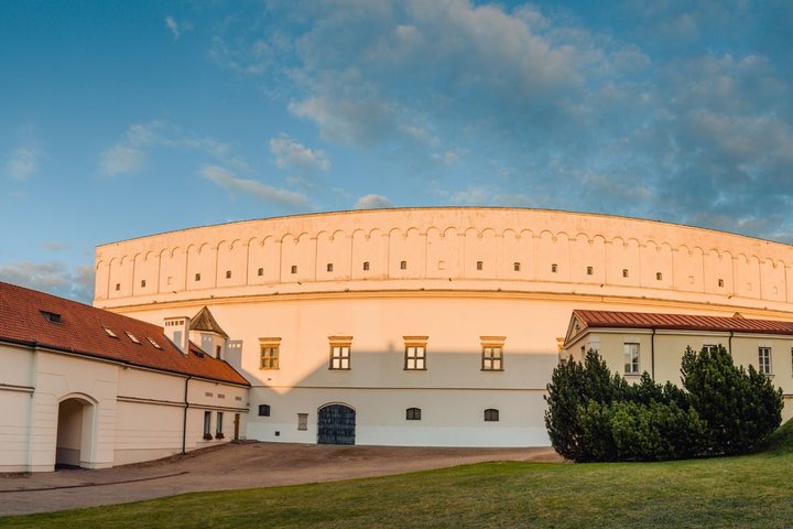 Vilniaus pilių teritorijoje esantis Senasis arsenalas – didelis pusapvalės formos istorinis pastatas su šviesiomis sienomis ir nedideliais langais. Pastatą supa kiemas ir žolė, šonuose matyti žemesni pastatai su raudonų čerpių stogais.