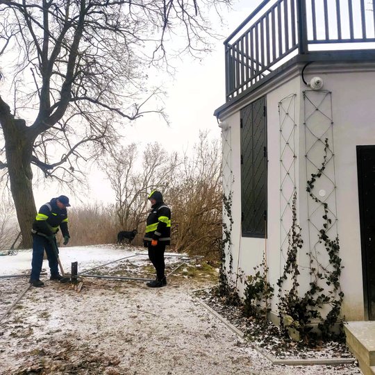 Nedidelis apžvalgos paviljonas ant kalvos su terasa viršuje. Aplink – žiemos peizažas su medžiais ir lengvu sniegu, o tolumoje matyti Gedimino kalnas su bokštu.