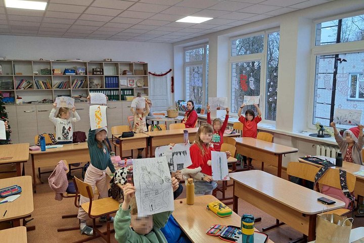 Pirmokai klasėje laiko iškeltus savo piešinius – svajonių pilis, sukurtas edukacijos metu Vilniaus Filaretų pradinėje mokykloje.
