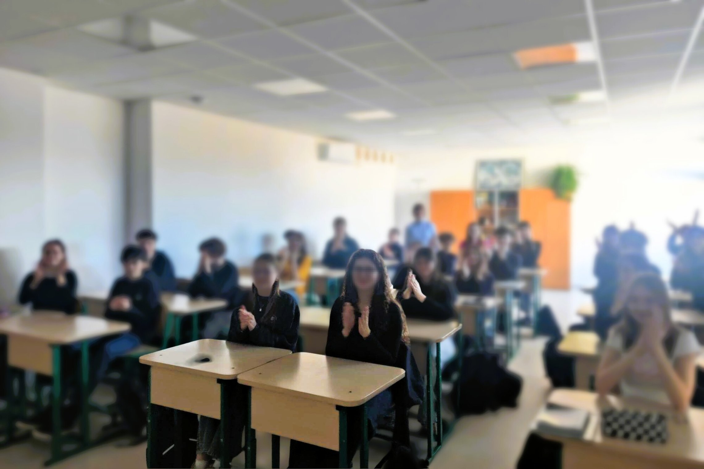 Mokiniai klasėje ploja po edukacinės veiklos apie Vilniaus pilių istoriją.