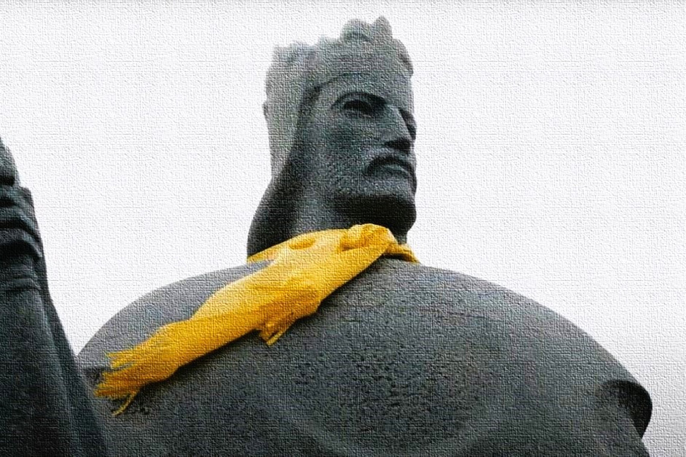 Paminklinė karaliaus Mindaugo figūra iš arti, ant kaklo užrištas geltonas šalikas, skulptūra perteikta tekstūros efektu, fonas pilkas ir neutralus.