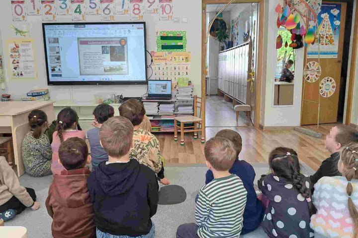 Vaikai susidomėję stebi skaidres apie kunigaikštį Gediminą ir jo sapną darželio grupėje. Priešais ekraną susėdę vaikai klausosi edukacijos apie Vilniaus įkūrimo legendą.
