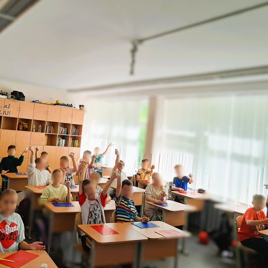 Kita klasė su moliniais darbais Dar viena klasė – vaikai entuziastingai laiko rankose molio darbus. Ant sienos pastebimas įkvepiantis šūkis „Taip, aš galiu!“, kuris dera su ugdomu pasitikėjimu savimi ir kūrybingumu. Klasėje šviesu, jauku, matosi mokyklinė