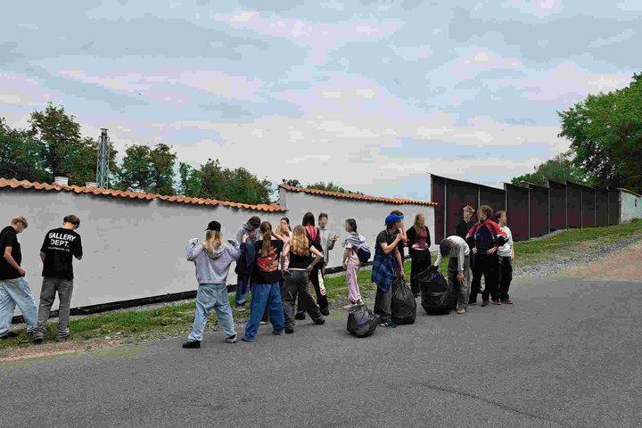 Grupė Šiuolaikinės mokyklos centro aštuntokų stovi Vilniaus pilių teritorijoje prie surinktų šiukšlių maišų po plogingo akcijos.