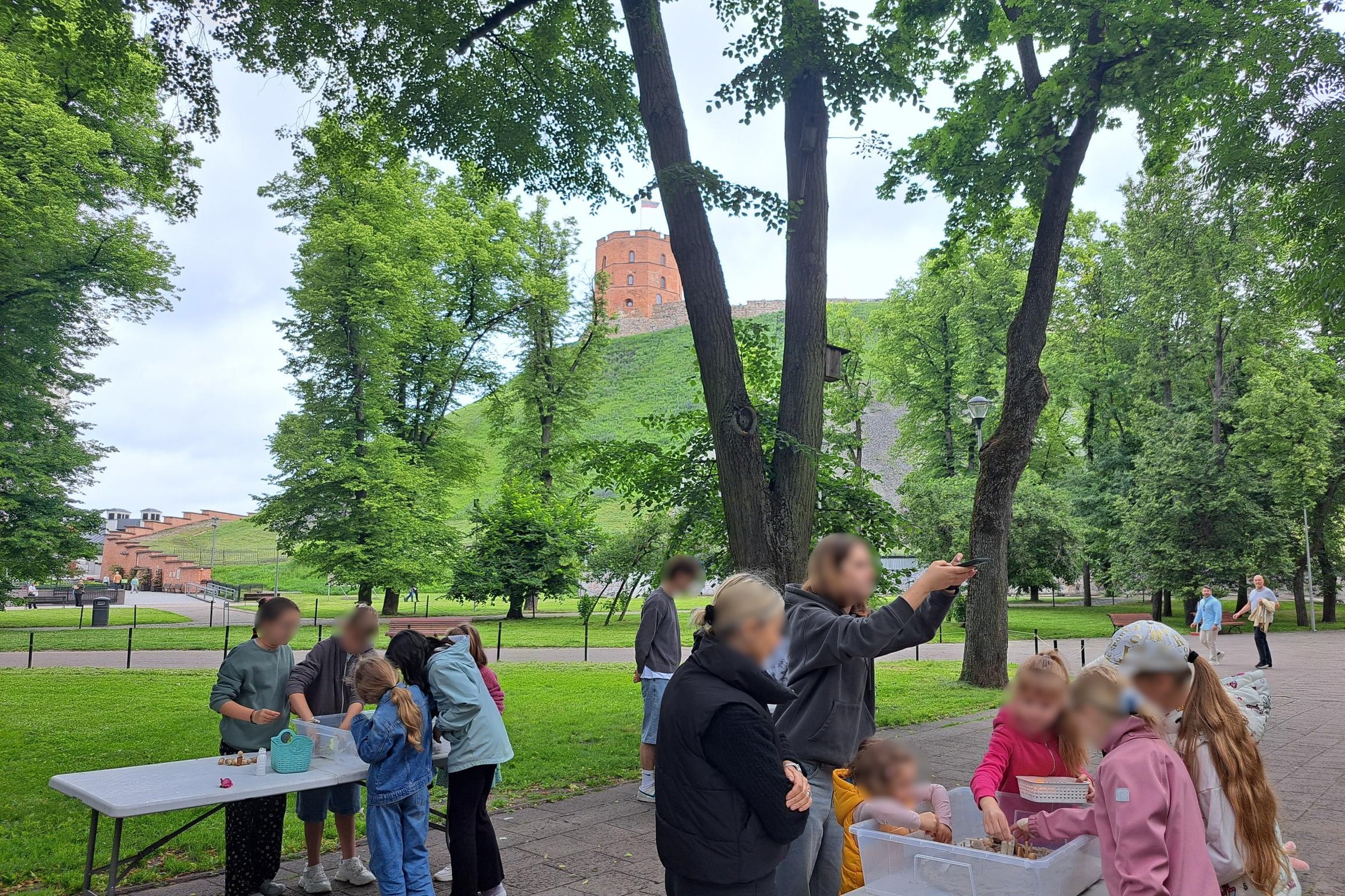Nuotraukoje matoma edukacinė veikla lauke, vaikai stato piliakalnius.