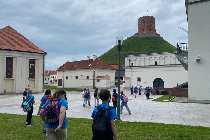 Mokiniai Žemutinės pilies kieme, fone – Gedimino bokštas