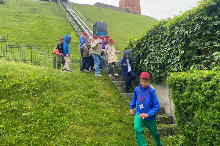Vaikai leidžiasi laiptais nuo Gedimino kalno šlaito netoli funikulieriaus, fone matyti Gedimino pilies bokštas