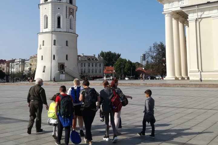 Vilniaus katedros aikštėje, link varpinės eina grupelė vaikų su ekskursijos vadovu. Graži vasaros diena. Danguje nėra nei vieno debesies. Ekskursijos vadovas pasipuošęs panašia į kareivišką aprangą.