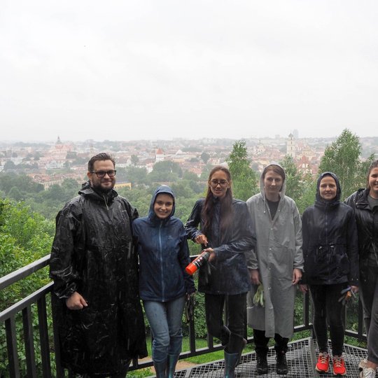 Savanoriai įsismarkavus lietui po darbų vykusios ekskursijos metu fotografuojasi ant Altanos kalno bokštelio.