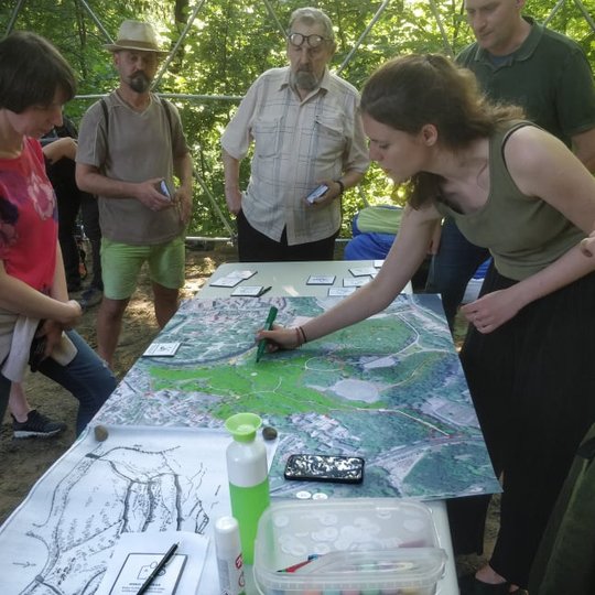 Nuotraukoje matoma žmonių grupelė stovinti aplink stalą. Viena moteris braižo ant didelio žemėlapio. Vyksta miesto planavimo žaidimas „Game of powers“, kurio metu persikūnijus į kitas roles (turisto, jaunimo, archeologo, verslininko ir t.t.) bandoma paieš