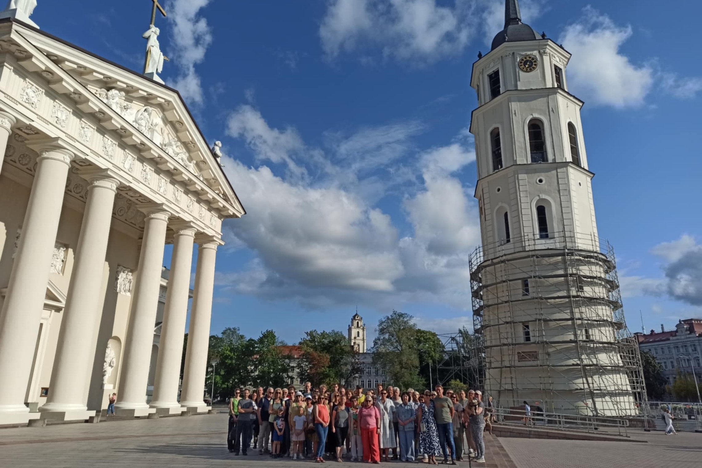 Nuotraukoje didelė žmonių grupė dalyvauja ekskursijoje „Vilniaus pilių laikrodžiai“