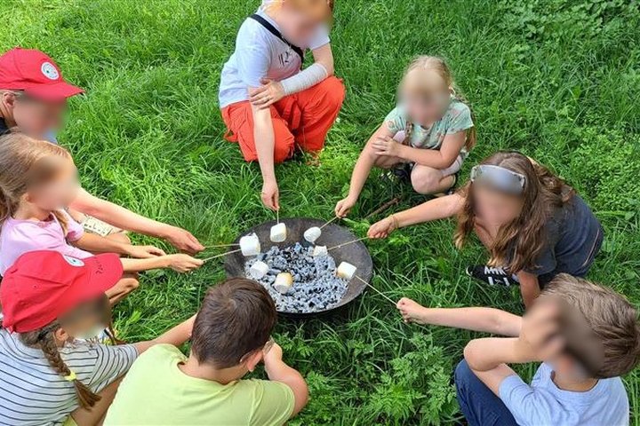 Nuotraukoje vaikai dalyvauja edukacijoje. Įamžinta finalinė veiklos akimirka, kai vaikai kepa zefyrus.