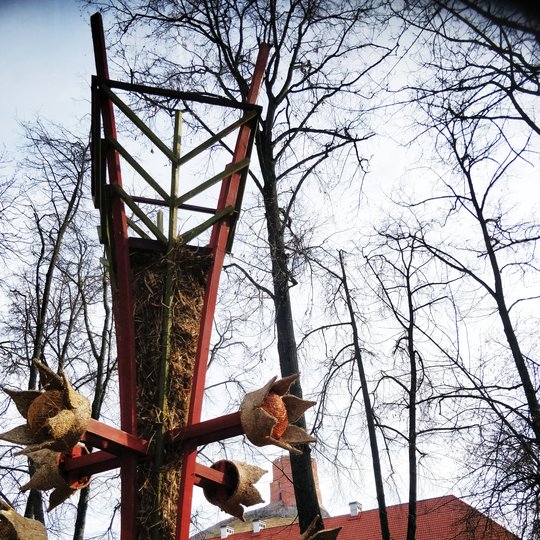 Mindaugo paminklo skvere dar neatsigavusi po žiemos veja. Ant vejos pastatyta milžiniška verba. Verbų skulptūros šiemet pasirinktos kaip Pavasario lygiadienį įprasminantis bei gyvybės medį atspindintis simbolis.