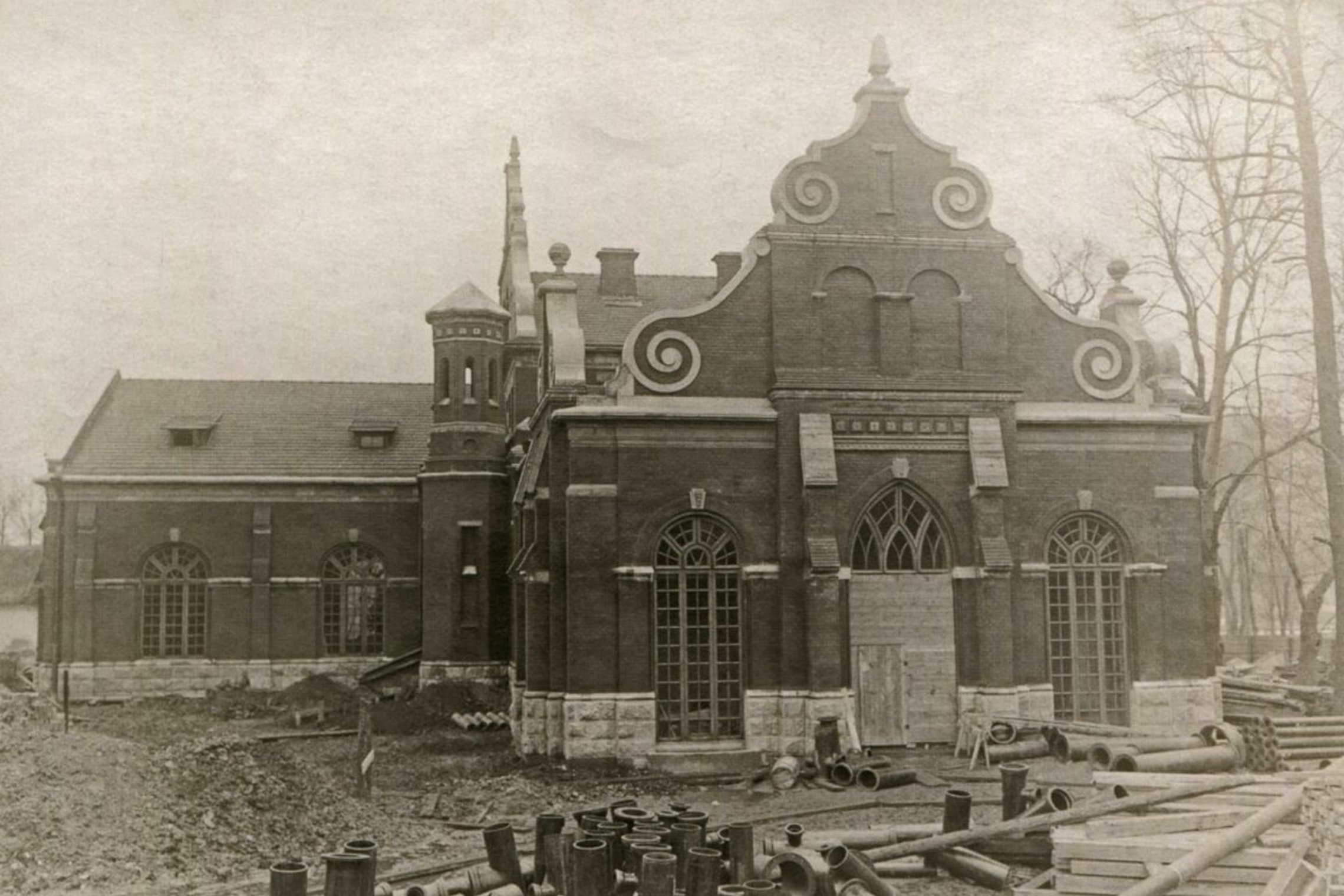 Vandentiekio siurblinė Bernardinų sode. J. Bulhako nuotrauka, 1914 m. Siurblinė nuotraukos fotografavimo metu yra statoma. Aplinkui pastatą mėtosi vamzdžiai ir kitos statybinės medžiagos.