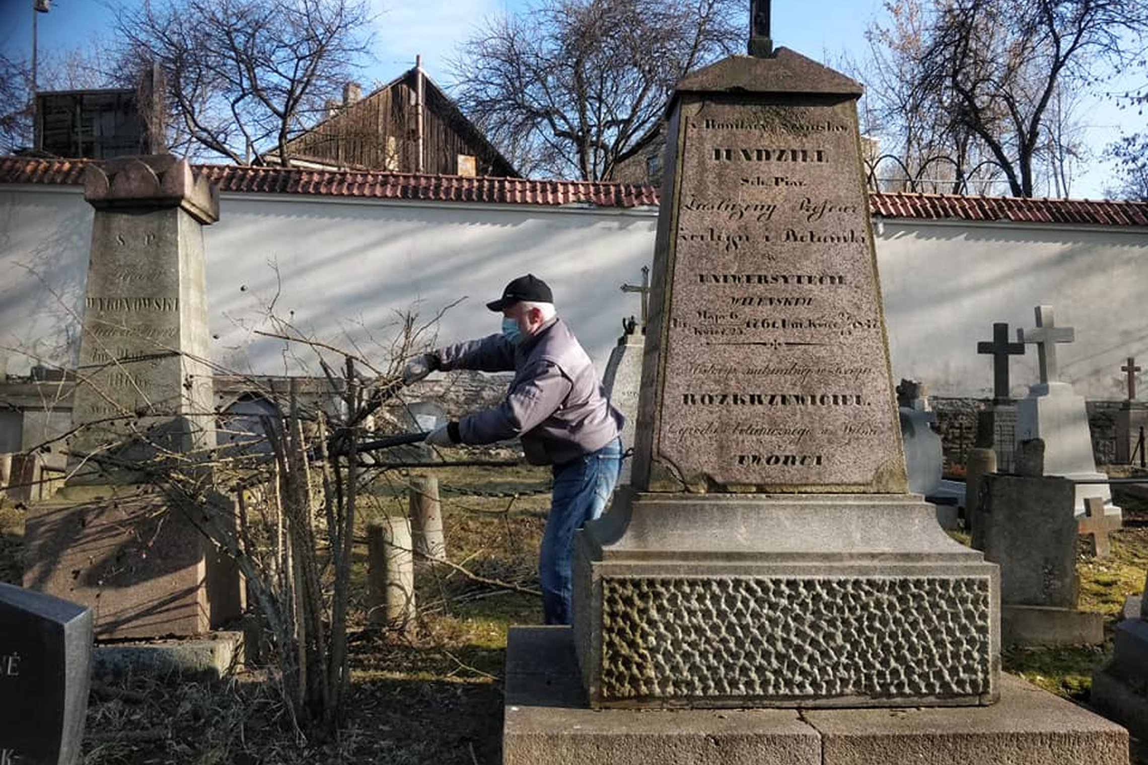 Bernardinų kapinės. Vilniaus universiteto profesoriaus S. B. Jundzilo kapas. Už paminklo žmogus karpo spygliuotą erškėtį.