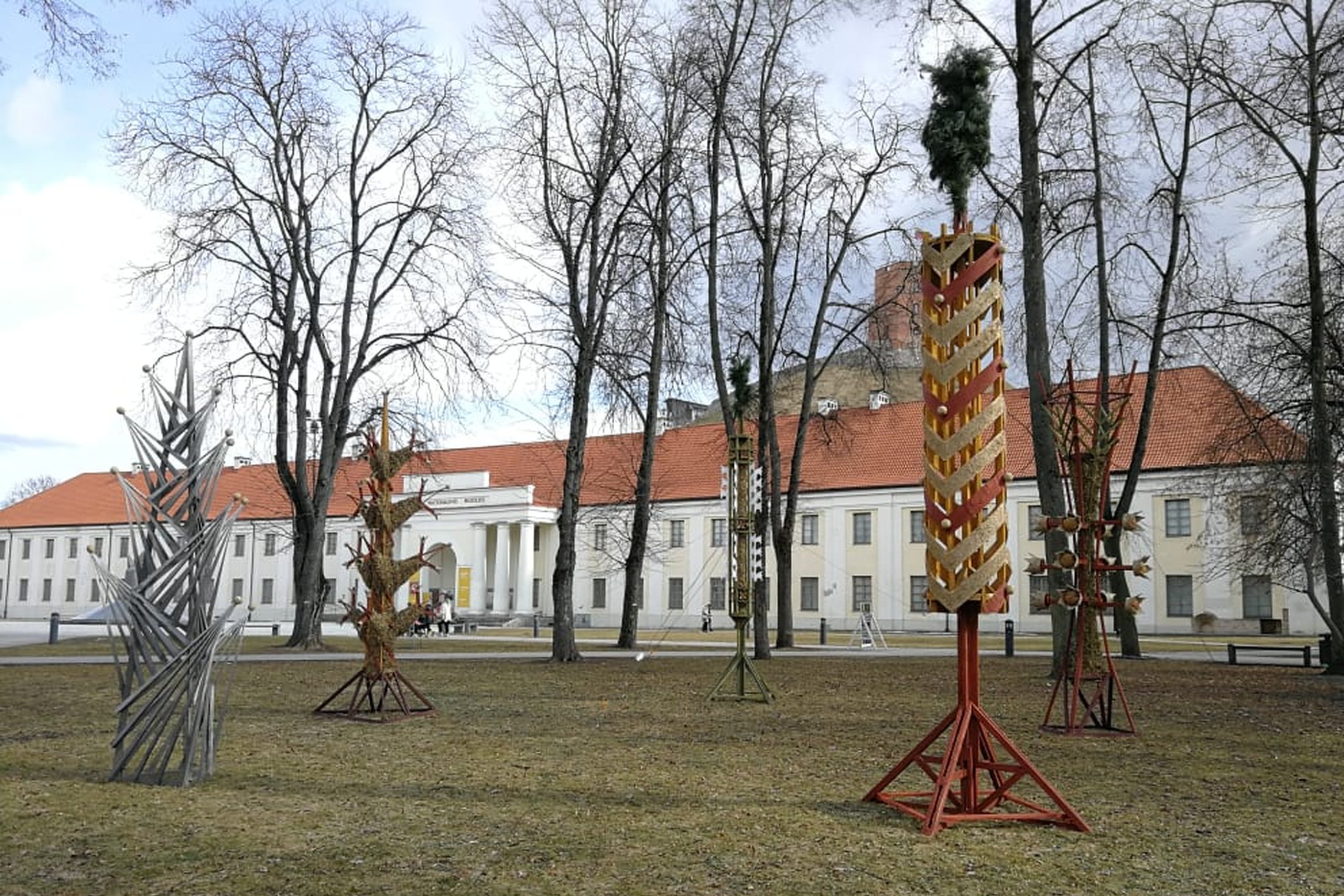 Mindaugo paminklo skvere dar neatsigavusi po žiemos veja. Ant vejos pastatyta milžiniška verba. Verbų skulptūros šiemet pasirinktos kaip Pavasario lygiadienį įprasminantis bei gyvybės medį atspindintis simbolis.