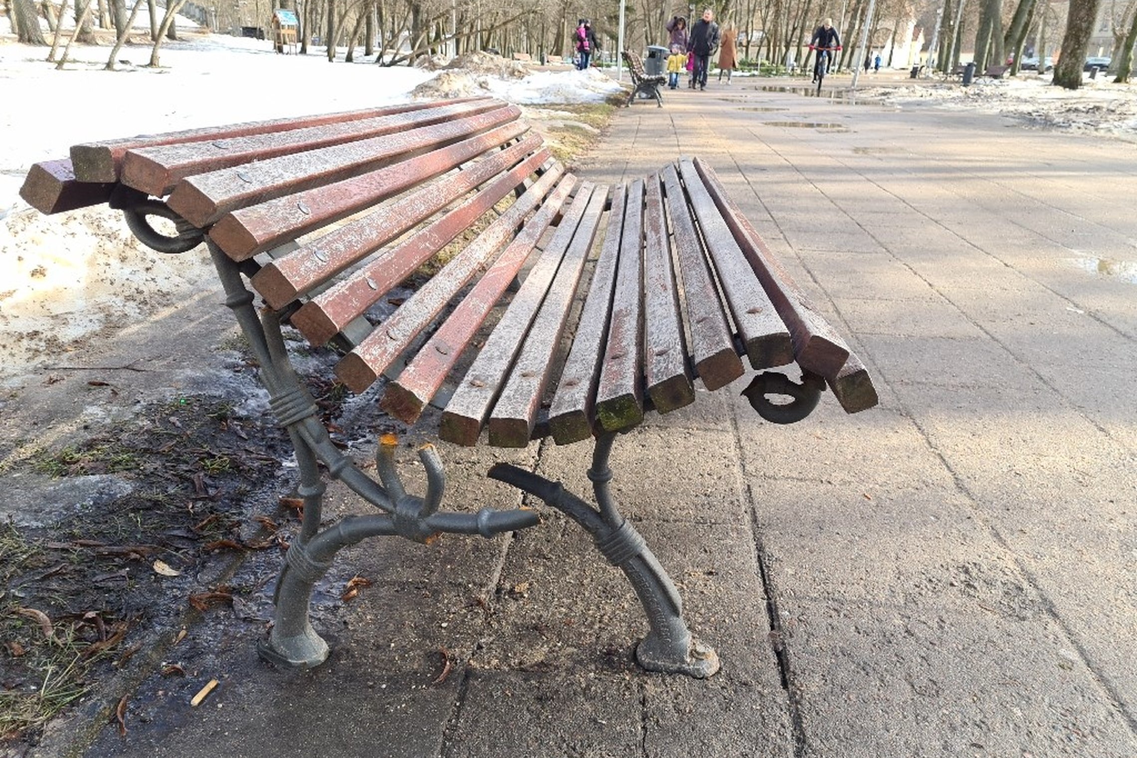 Sunkios žiemos neatlaikė lauko suoliuko kojos. Suolas yra Pilių parke. Suolas medinis, senas.