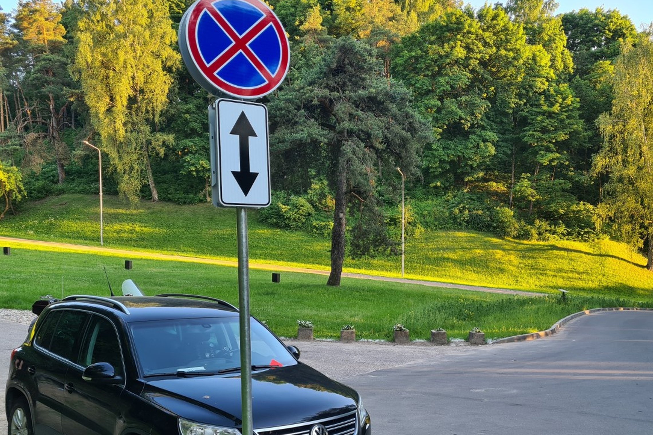 Draudžiantis parkuotis kelio ženklas. Kalnų parko estrados kelyje bei automobilių stovėjimo aikštelės pakraščiuose stovėti negalima. Ne visi Vilniaus pilių lankytojai paiso kelio ženklų ir turi savo „nuosavas vairavimo“ taisykles.