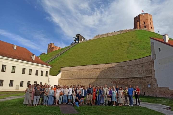 Nuotraukoje didžiulė žmonių grupė dalyvauja ekskursijoje.