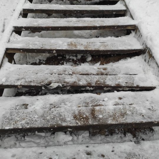 Mediniai laiptai su keliomis įlūžusiomis pakopomis. Aplink daug sniego. Laiptai nėra nauji, juos teks remontuoti.