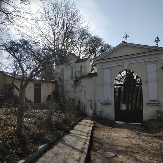 Bernardinų kapinių vartai. Graži pavasario diena, šviečia saulė, giedras be debesų dangus.