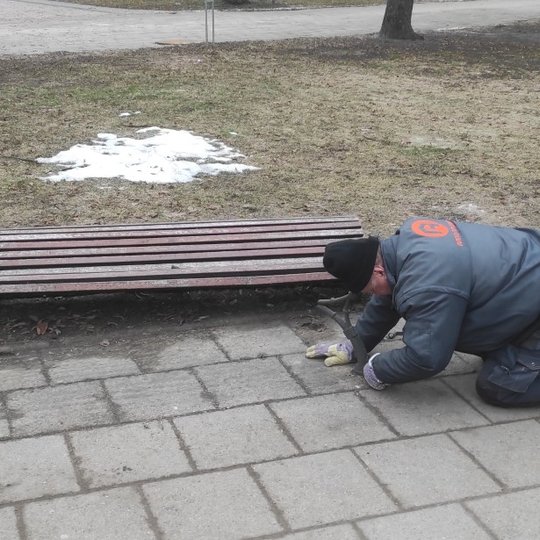 Išvežamas sunkios žiemos neatlaikęs lauko suoliukas.